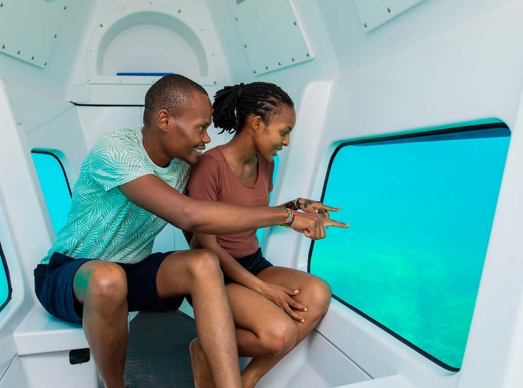 Couple observant la vie marine à l’intérieur d’un semi-sous-marin de Zanzibar